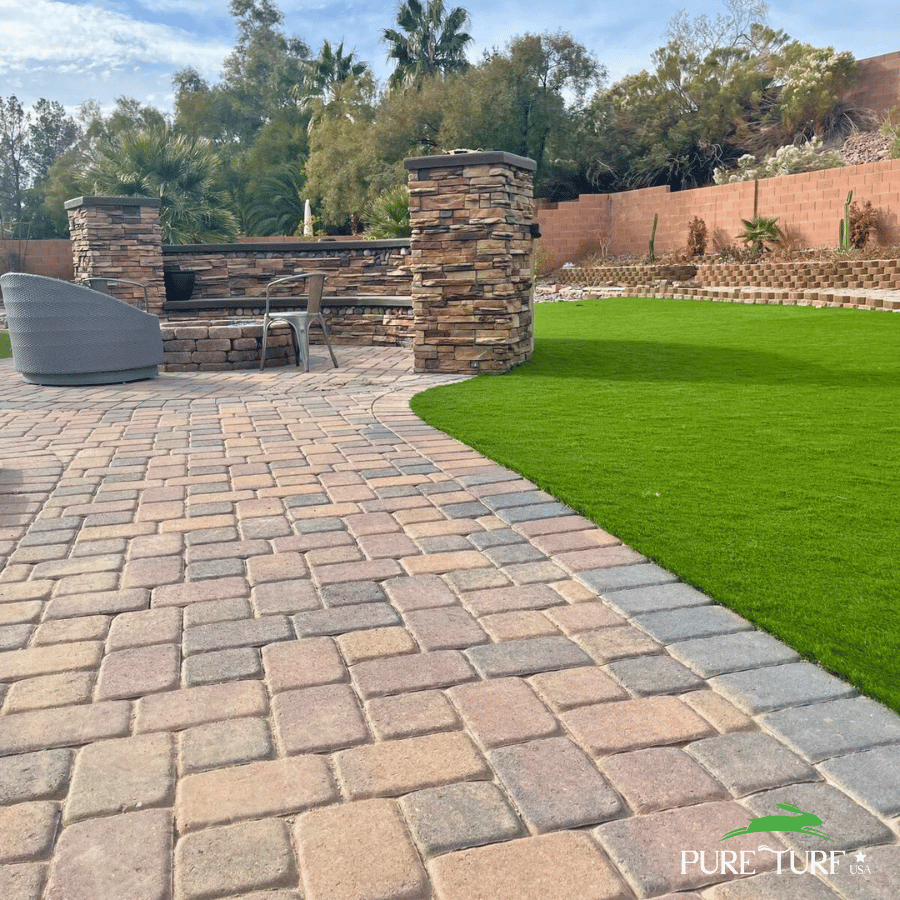 Paver patio with fresh artificial turf lawn
