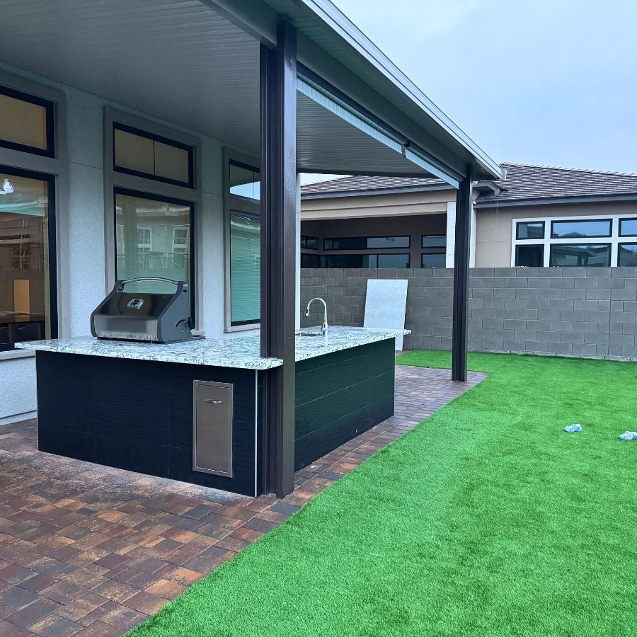 Outdoor kitchen island next to artificial turf lawn