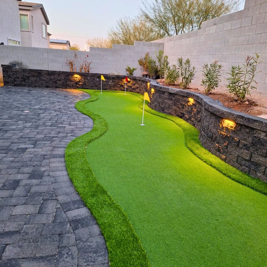 Backyard putting green with flags and landscape lighting